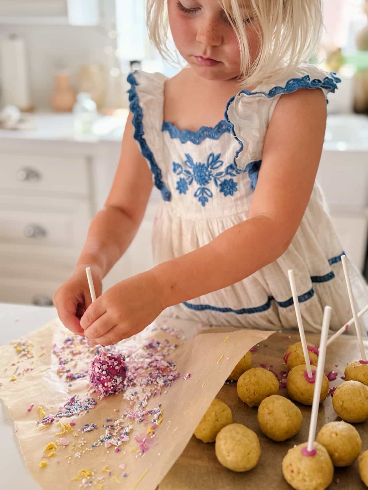 Adding sprinkles to cake pops