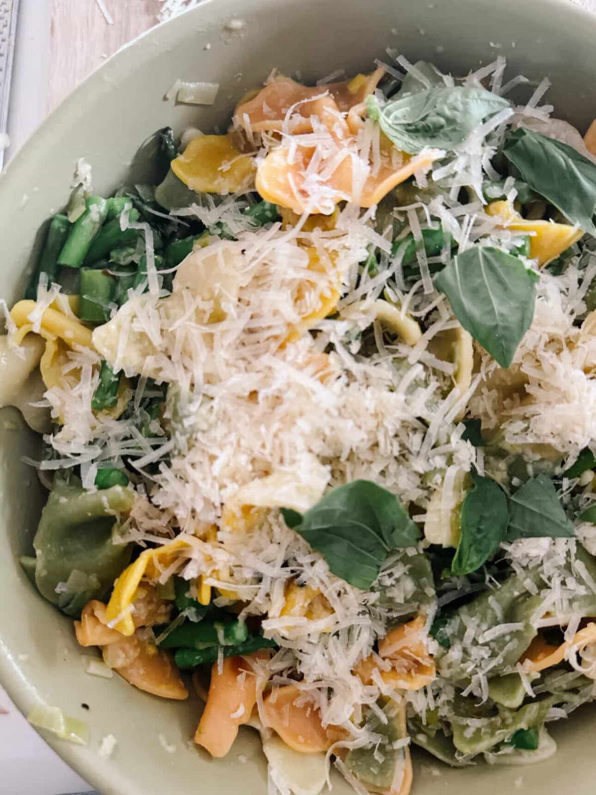 Pasta dish with greens and parmesan cheese in a bowl