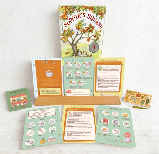 Educational materials including a book titled 'Sophie's Squash' and various cards on a white surface.